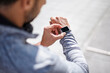 © Westend61 - Man in sportswear checking smartwatch during running break in city