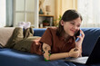 © Westend61 - Smiling girl with prosthesis talking on smartphone at home
