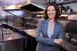 © wavebreak3 - Senior woman supervising salad plating in restaurant kitchen with steel counters, copy space