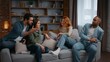 © Yuliia - Multiracial four friends at home party talking on couch emotional discussion arguing smiling diverse people communicate in living room women girls men guys together conversation debate problem discuss