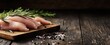 © Studio Nova - The Raw Chicken Breast Fillets on Rustic Cutting Board with Rosemary and Sea Salt