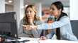 © Bojan - Young businesswoman pointing at monitor explaining task to senior colleague at desk