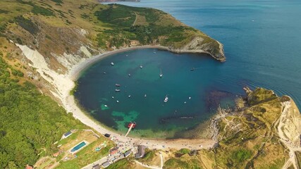 Wall Mural - Drone flying forward with downward pan of Lulworth Cove on the Jurassic Coast