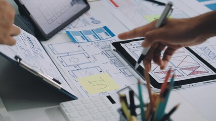 Group of young application developers analyzing uxui mobile app templates during a working meeting