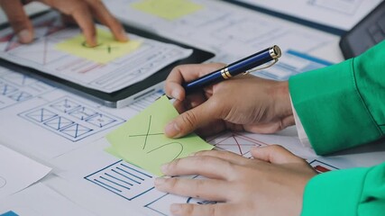 Group of young application developers analyzing uxui mobile app templates during a working meeting