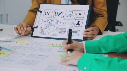 Group of young application developers analyzing uxui mobile app templates during a working meeting