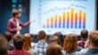 © Anna - A person presenting a chart to an audience in front of a projector