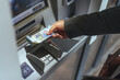 © Dragana Gordic - Close-Up of Hands Withdrawing Money From an ATM Machine