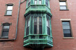 Aged copper bay window with verdant patina gracing a historic brick building in Cambridge,  Massachusetts, USA
