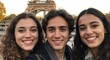 Selfie d’amis – deux jeunes Parisiennes et un jeune homme devant une tour de France