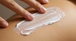 © Proyek - Hand spreading white cream on skin fingers applying lotion evenly