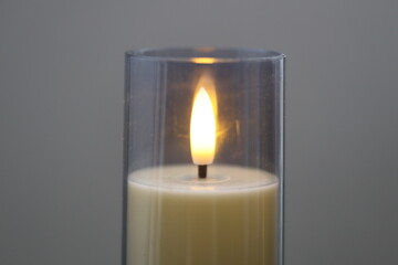 Wall Mural - A single candle sits in a glass container, surrounded by darkness