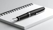 © Ardhia - Elegant black fountain pen with silver nib placed diagonally on a white notebook, minimal background
