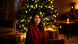 © Simon - - Young woman smiling while sitting by Xmas tree in cozy living room