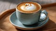© tope007 - A cup of coffee with a swan design on it sits on a wooden tray