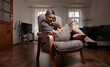 © Seva Zelikoff - Smiling woman with sphynx cat on armchair in bright room