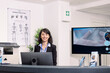 © DC Studio - Hospital front desk with friendly caucasian female receptionist standing in clean, modern medical lobby. Professional clinic staff member ready to assist patients with registration.