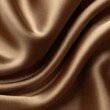 © King - Close-up of luxurious, flowing, golden-brown silk fabric.  Smooth, draped folds create a luxurious texture