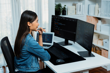 Young Asian IT developer looking online information on pc for beautiful pose with coding program data of website application, wearing jeans shirt. surround by safety analysis two screens. Stratagem.