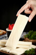 © CaoVan - Fresh Rice Paper Sheet Held by Hand for Asian Cooking with Kitchen Ingredients