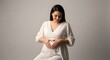© Pixcellence - Elegant maternity portrait with expectant mother in white dress creating heart shape on belly for pregnancy announcement or baby shower design