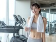 © Jumpei - ジムで運動後に笑顔で水を持つフィットネス女性