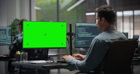 Software Developer Working on Computer with Green Screen Mock Up Display, Writing Source Code for an App in Office. IT Programming Department Researching and Developing Online Software