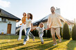© Maria Vitkovska - Happy family running in the garden of their house with solar panels