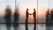 © hao - Business agreement concept showing blurred silhouette of business people shaking hands near large window in office building showing blurry cityscape. High quality