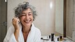 © pibi37.studio - Smiling Older Woman Applying Makeup In Bathroom. Embracing Beauty And Self-Care At Any Age