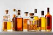 © Apisit - Assortment of whiskey, rum, and liquor bottles filled with amber-colored spirits arranged on a reflective surface, showcasing premium alcoholic beverages and elegant glass designs,