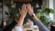 © Studicon - Three individuals of different ethnicities are shown giving each other a high five, signifying teamwork and success in a collaborative workspace.