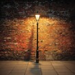 © Tarakan - A solitary lamp post casts a shadow against a weathered brick wall at night