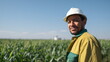 © xuxu - Close-up of a smiling hispanic male industrial worker looking at the camera with a field in the background. Industrial safety.
