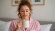 © Violet - Young woman sipping coffee while relaxing in bedroom on weekend