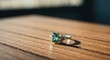 © Lemdah - Close-up of a ring with a green gemstone resting on a wooden surface