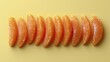 © melvilsky - Fresh tangerine segments arranged in a row on a yellow background.