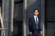 © Nalinee - Confident young professional walking along a busy city street in the financial district, showcasing modern corporate attire and the daily work routine of an ambitious businessman in the city