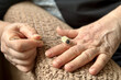 © vipvn - An unknown elderly woman makes herself a hand massage with her hand with a massager in the form of a needle-shaped silver roller