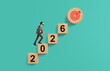 © ImageFlow - Businessman climbing 2026 wooden steps toward goal icon on turqu