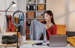 © David - Asian woman describe selling clothes on camera live broadcast on social network at home, Online selling clothes on social media. Blogger woman influencer, SME retail store owner.