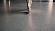 © maxximmm - Person walking on concrete floor. Person is walking on barefoot floor in an indoor space. A reflection of a calming ambiance with shadows and a quiet movement. An individual strolling on a lifestyle.