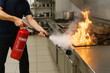 © Hellen - Sujeto apagando incendio en cocina con un extintor