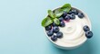 © Kremuzz - Yogurt Bowl with Blueberries and Mint Leaves.