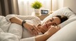 © Istar - Woman sleeping peacefully in bed with alarm clock in background.