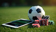 © Vadym - Soccer ball and casino chips on green grass. Tablet displays online sports betting interface. Concept blends football with gambling and digital technology.