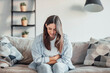 © Daniel - One woman suffering from stomachache alone at home, holding her belly, touching and massaging abdomen. Bad sick face feeling discomfort and diarrea