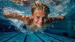 © Caspernik - Joyful Caucasian boy swimming underwater with arms outstretched in clear blue pool, smiling directly at camera with bubbles surrounding him in competitive swimming environment