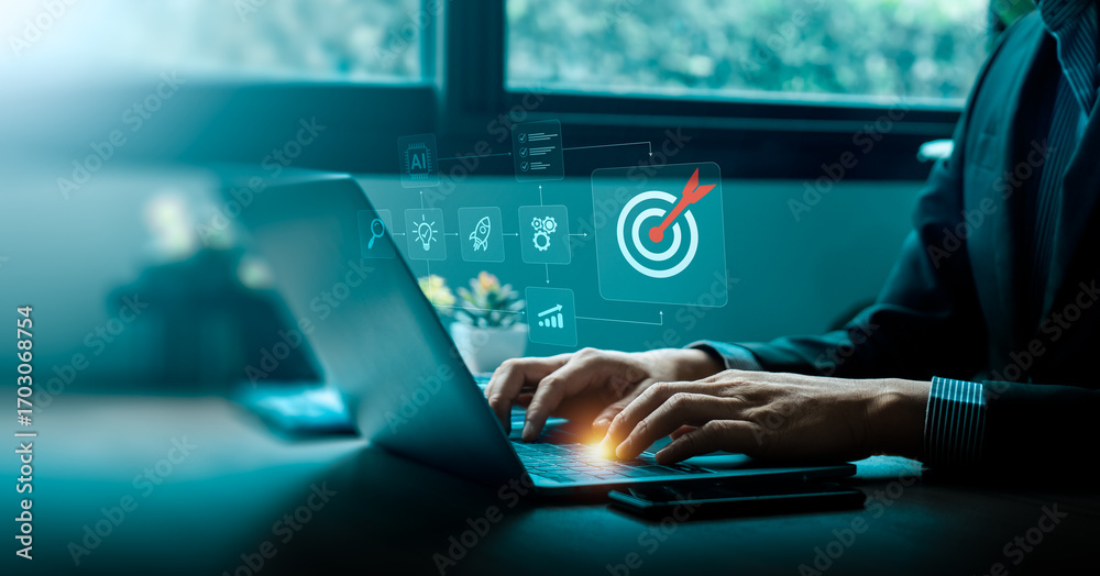 Target Symbpolising Process Businessman using laptop with virtual interface showing target icon and ...