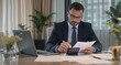 © Birul - Businessman reviewing financial documents at his desk